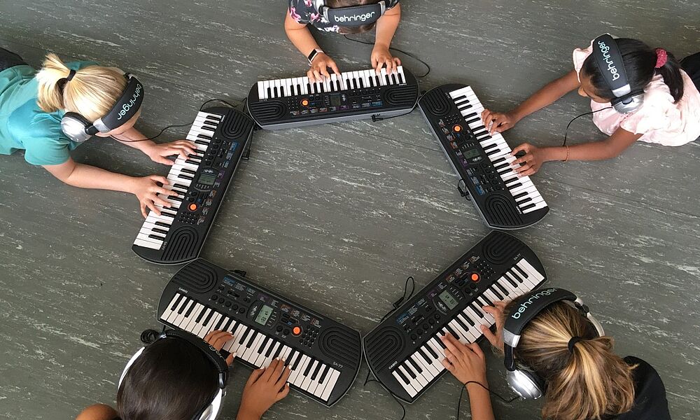 Fünf Kinder an Mini-Pianos