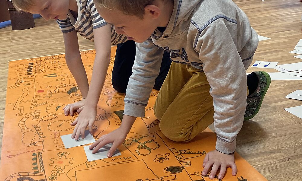 Kinder auf Bodenplakat